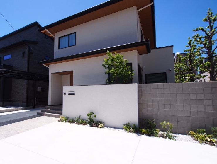 大きな白い塀が目を引く、奥行きのあるデザイン