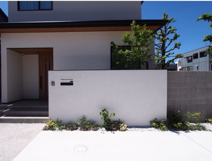 大きな白い塀が目を引く、奥行きのあるデザイン